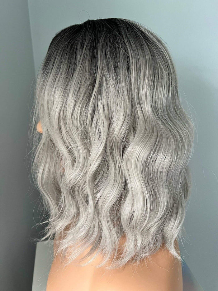 Silver hair with wavy texture against a neutral background