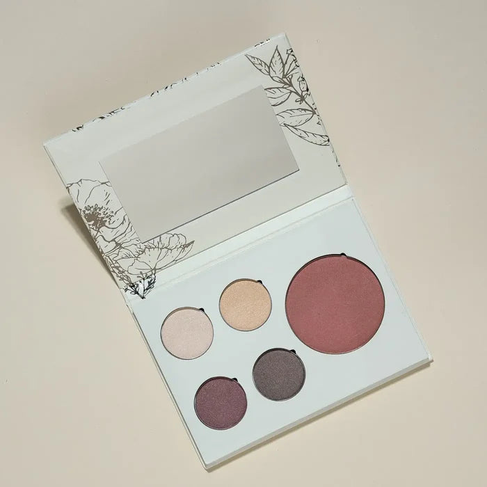 Makeup palette with five round compartments on a beige background