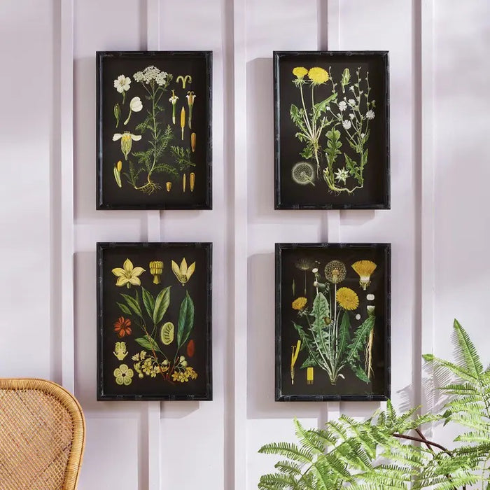 A cozy living room features a white armchair, neutral pillows, a basket, a white brick fireplace with candles inside, and four NAPA HOME AND GARDEN Golden Botanical Study wall art prints above the mantel.