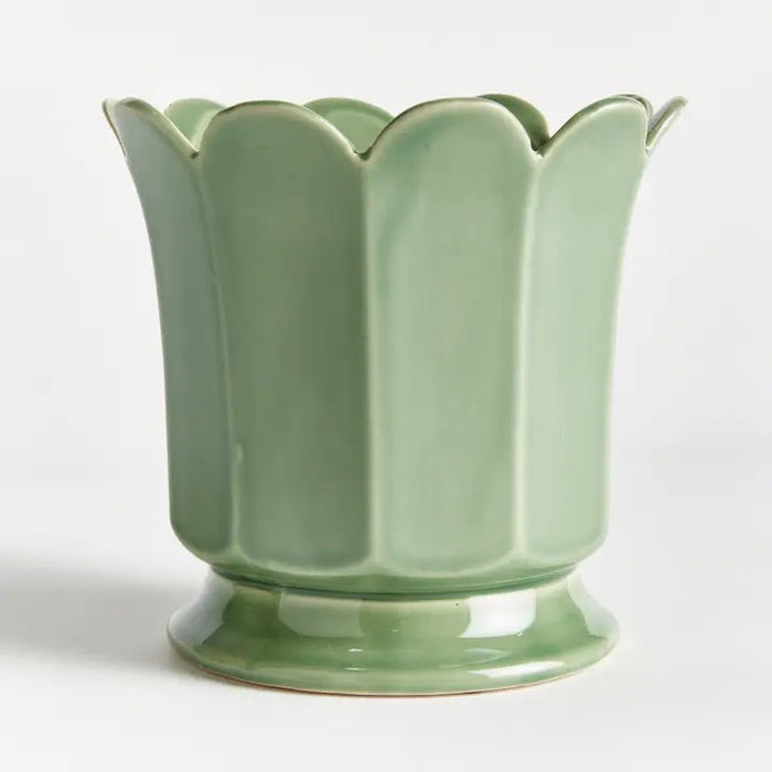 The NAPA HOME AND GARDEN Maline Footed Pot in Green, Large, features a light green ceramic finish with a scalloped, petal-like rim and a flared, rounded base. This elegant vase by NAPA HOME AND GARDEN is photographed against a plain white background.
