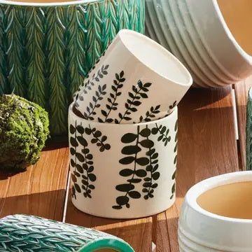 The NAPA HOME AND GARDEN Maren Pot, Small, features embossed leafy designs on white ceramic—a perfect orchid vessel to pair with its larger counterpart for a coordinated display.