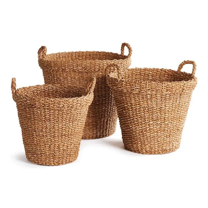 The NAPA HOME AND GARDEN Seagrass Tapered Basket with Handles and Cuff, Large, is shown from above, highlighting its natural seagrass texture and expert craftsmanship on a matching surface.