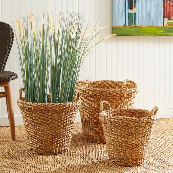 The NAPA HOME AND GARDEN Seagrass Tapered Basket with Handles and Cuff, Large, is shown from above, highlighting its natural seagrass texture and expert craftsmanship on a matching surface.