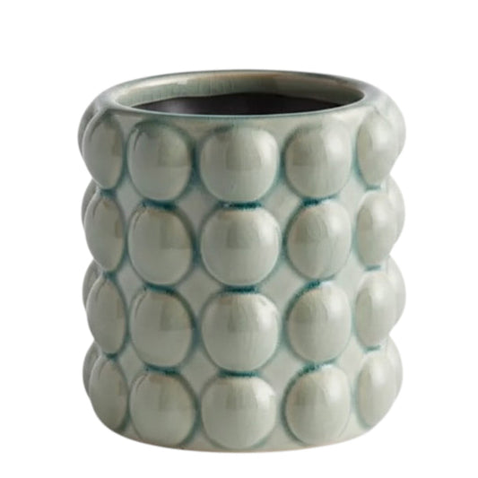 The NAPA HOME AND GARDEN - VALENCIA POT, SMALL by NAPA HOME AND GARDEN is a light green contemporary planter with a glossy seafoam glaze and a textured surface featuring raised circular bumps arranged in a grid pattern.