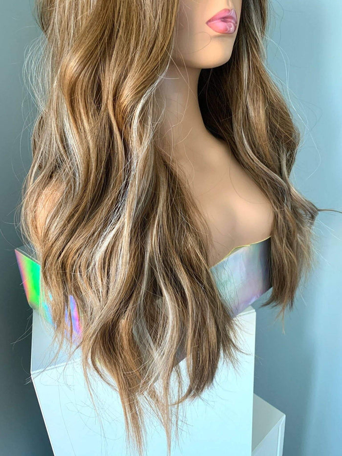 Mannequin head with long, wavy brown hair on a plain background