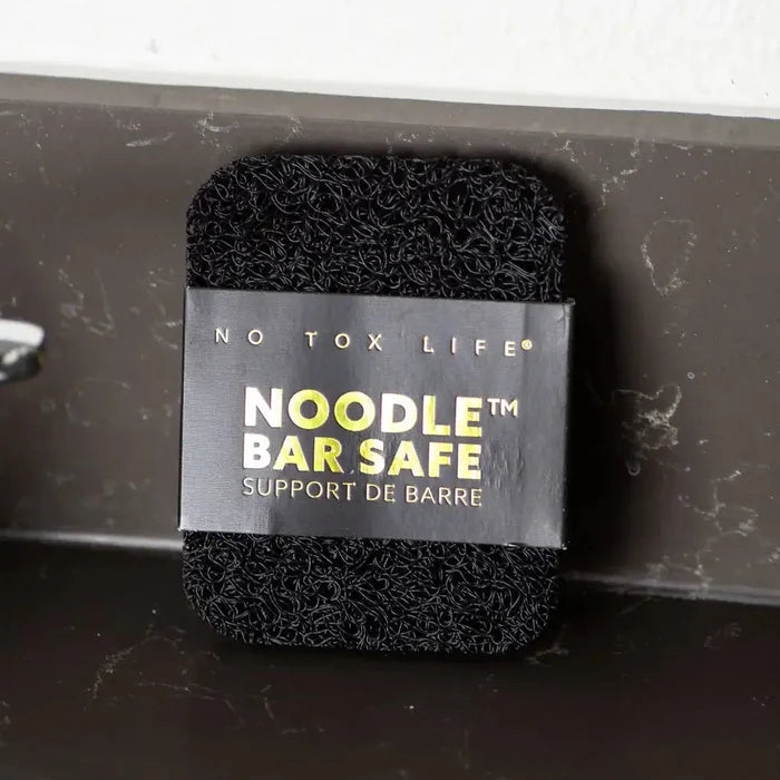 Black foam noodle bar safety support with 'No Tox Life' label on a gray background