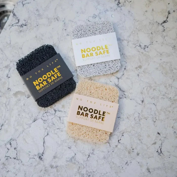 Three sponges labeled 'Noodle Bar Safe' on a marble surface