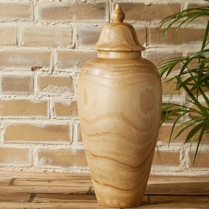 The PAULOWNIA WOOD COVERED TEMPLE JAR - SMALL by TWO'S COMPANY features a light brown paulownia wood construction with a rounded body, subtly narrow base, and a decorative lid. Its visible wood grain offers a natural and smooth look, making it an exotic accent piece for the home. The jar is shown standing upright against a white background.