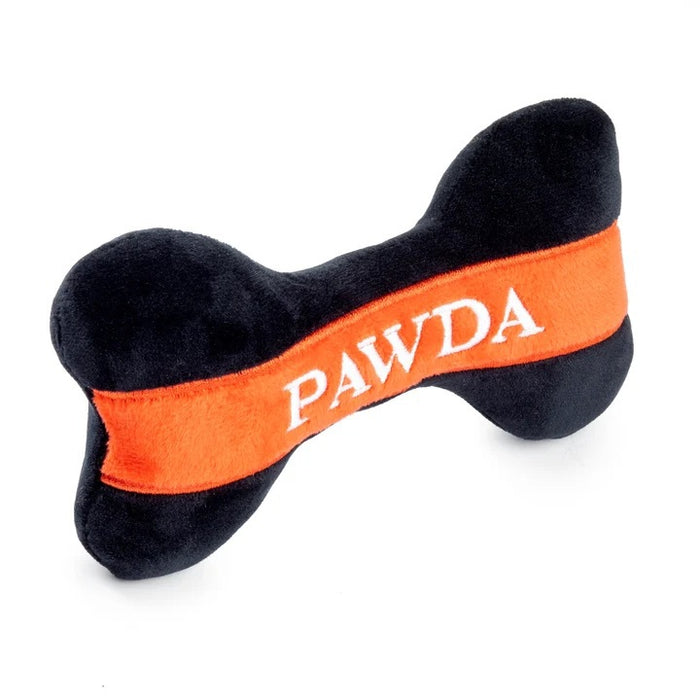 The HAUTE DIGGITY DOG PAWDA BONE DOG TOY is a chic black and orange plush bone with "PAWDA" embroidered in white on the orange stripe—an essential accessory for your stylish pup.