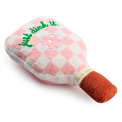 The HAUTE DIGGITY DOG PINK CHECKER PICKLEBALL PADDLE DOG TOY is a plush, paddle-shaped squeaky dog toy featuring a fun pink checkered design, an embroidered pickleball, the phrase "just dink it." in green, and a brown handle—perfect for pups who want to join in on your pickleball passion.
