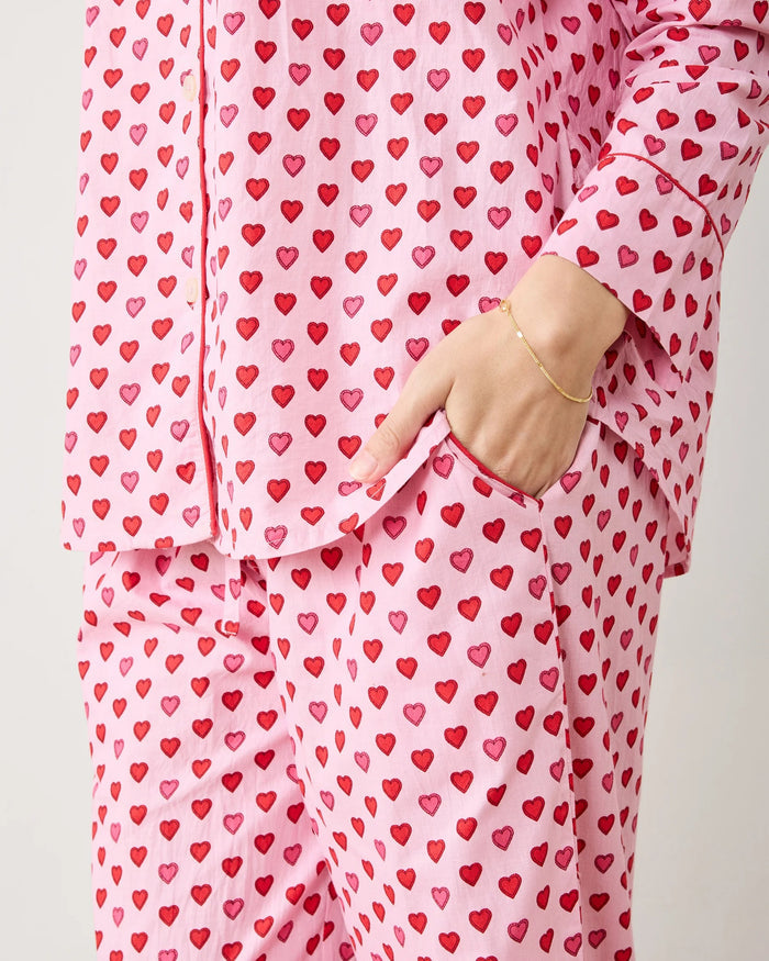 A seamless pattern of red and pink hearts arranged in neat rows on a light pink background, featured on the PRINTFRESH - MINI CANDY HEARTS LONG PAJAMA SET by PRINTFRESH, perfect for cozy Valentine's pajamas.