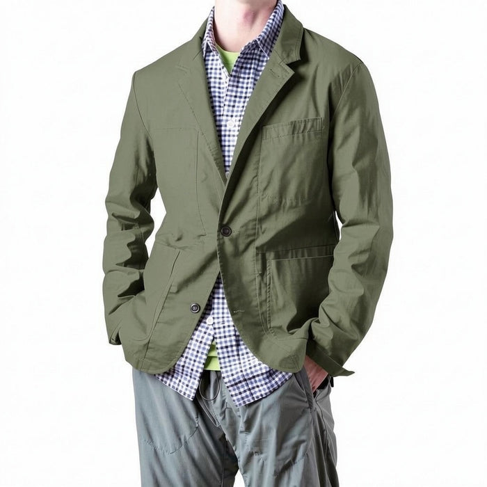 A person models the RELWEN Flyweight Flex Blazer in Burnt Olive over a blue and white checkered shirt with gray pants, hands in pockets, against a plain white background.