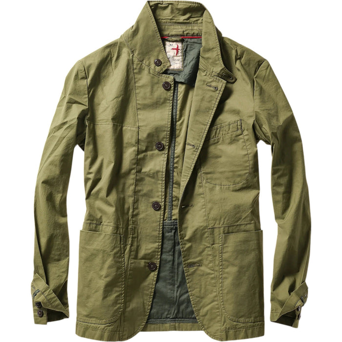 A person models the RELWEN Flyweight Flex Blazer in Burnt Olive over a blue and white checkered shirt with gray pants, hands in pockets, against a plain white background.