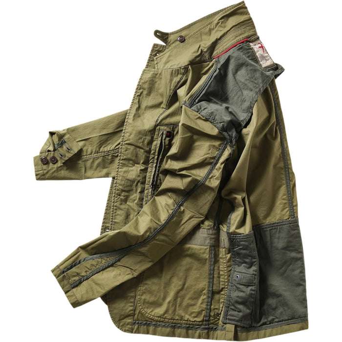 A person models the RELWEN Flyweight Flex Blazer in Burnt Olive over a blue and white checkered shirt with gray pants, hands in pockets, against a plain white background.