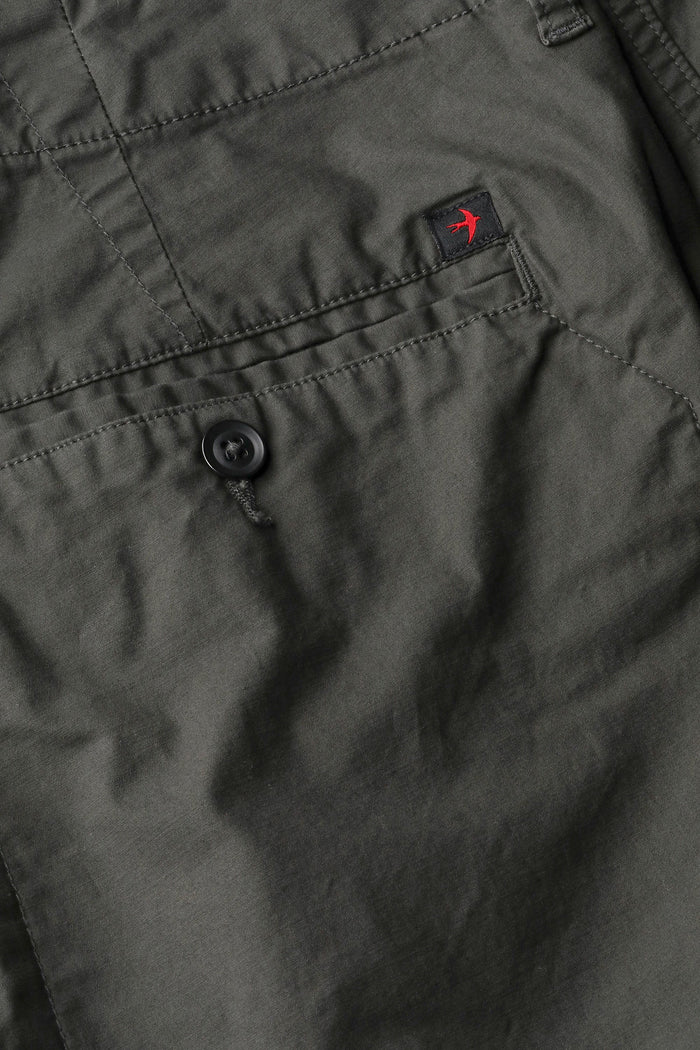 The RELWEN Flyweight Flex Chino in Charcoal, shown from the back with two buttoned pockets and subtle wrinkling, features a slim, straight-leg fit and lightweight stretch fabric for comfort. Pants are displayed flat on a white background.