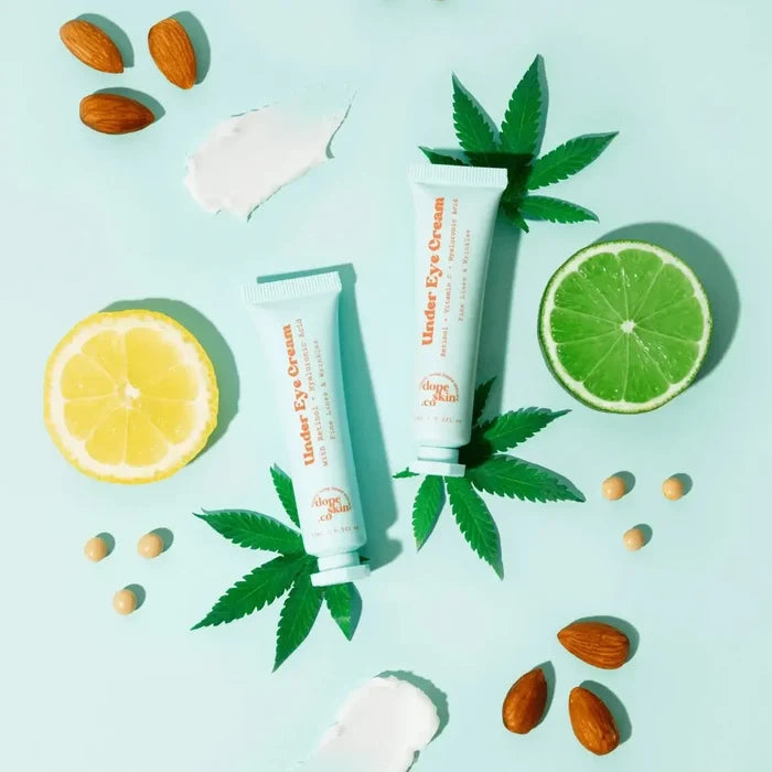 Two tubes of Under Eye Cream with lemon, lime, and cannabis leaves on a light blue background