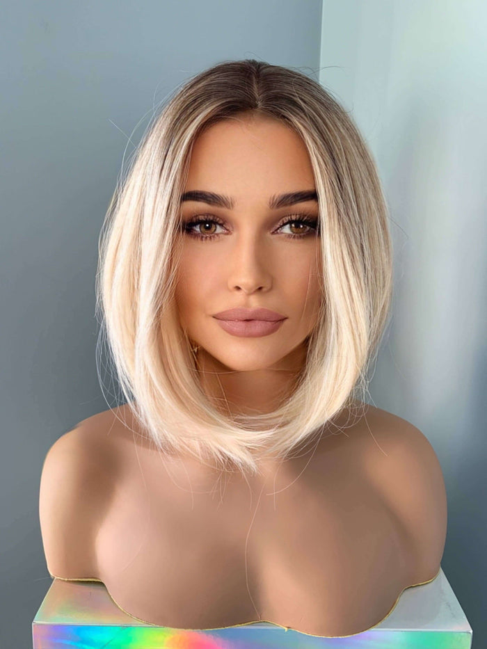 Sadie Short Blonde Rooted Wig displayed on a mannequin with a sleek bob style and soft angled cut.
