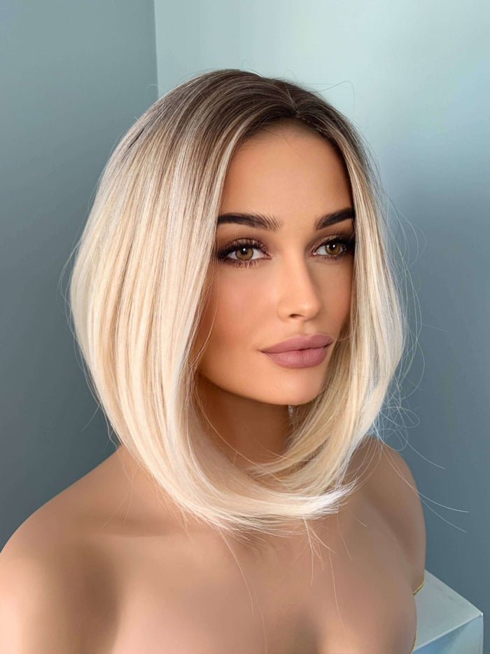 Sadie Short Blonde Rooted Wig showcasing a sleek bob hairstyle with a center part for a polished look.