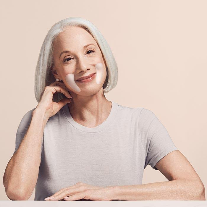A pink package labeled "SIO EYE AND SMILE" from SIO BEAUTY sits beside a card showing two white, crescent-shaped medical grade silicone patches on a pale pink background.