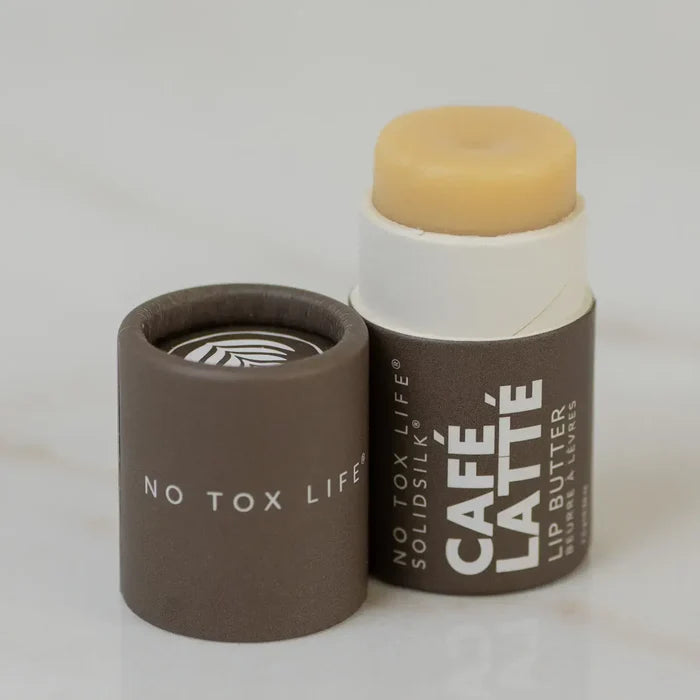 Lip balm stick with brown packaging labeled 'Café Latè' on a light gray background