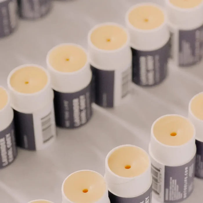 Multiple small cylindrical containers with white caps on a gray surface