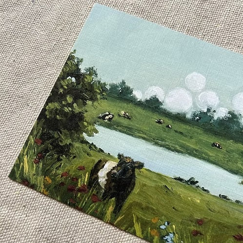Bring home the charm of the countryside with the SOPHIE WYATT STUDIO - WILD MEADOWS & BELTIES ART PRINT, 11X14. This fine art print by SOPHIE WYATT STUDIO features a scenic green landscape with a pond, trees, colorful flowers, and Belted Galloway cows under puffy white clouds on linen fabric.