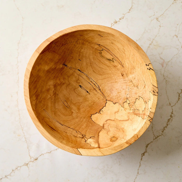 A handcrafted SPENCER PETERMAN - SPALTED MAPLE BOWL 13" by PETERMANS BOARDS & BOWLS INC, featuring a round shape with a light, natural finish and striking spalted maple grain patterns, displayed on a white background.