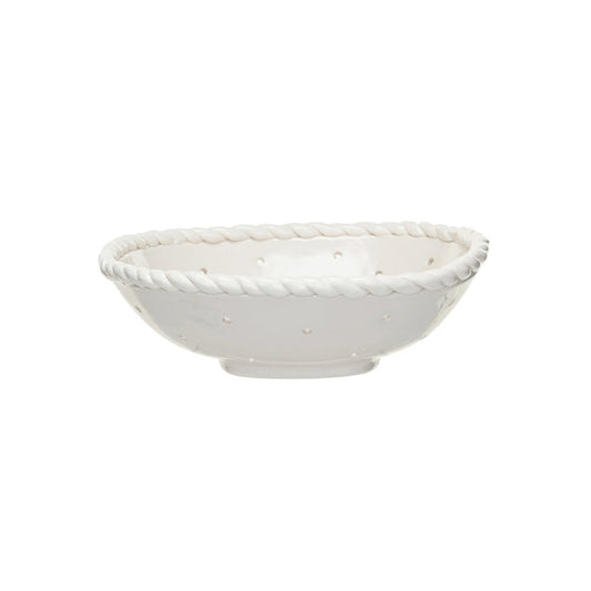 The CREATIVE COOP STONEWARE COLANDER WITH HAND TWISTED EDGE, shown holding three grapefruits on a light textured surface, adds farmhouse charm to any kitchen.
