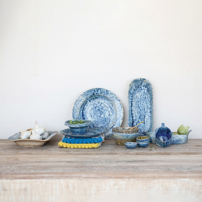 The CREATIVE COOP STONEWARE DISH IN BLUE REACTIVE CRACKLE GLAZE features two glossy, crackle-glazed bowls—one upright, one inverted—against a white backdrop; perfect as a rustic jewelry holder or serving piece.