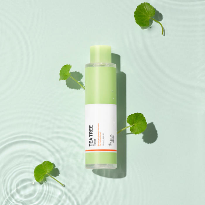 Skincare bottle with tea tree oil on a light green background
