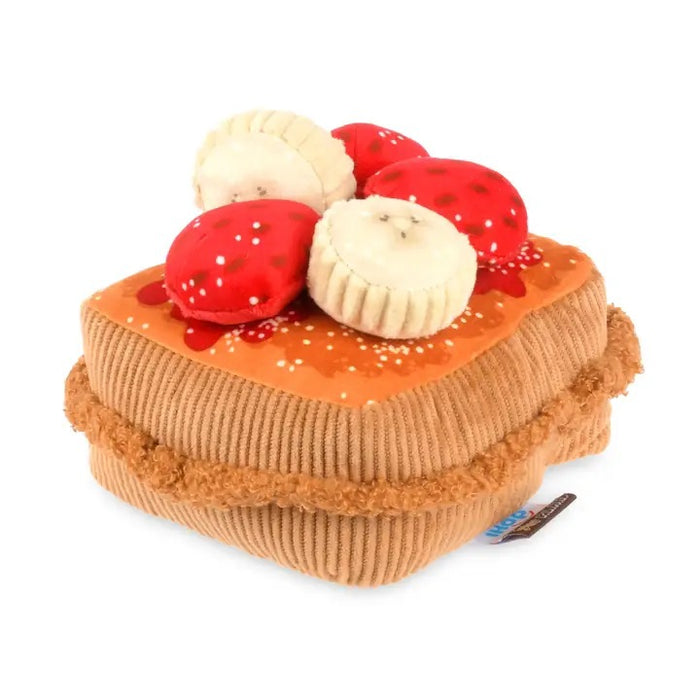 The THICK ‘N FLUFFY FRENCH TOAST DOG TOY by PLAY PET LIFESTYLES/BRANDS is a plush, squeaky dog toy designed to look like a delicious stack of French toast, topped with fabric strawberries, bananas, and syrup. Its soft texture and detailed brown edges resemble a real breakfast treat—perfect for pets who love an eco-friendly toy that looks good enough to eat.