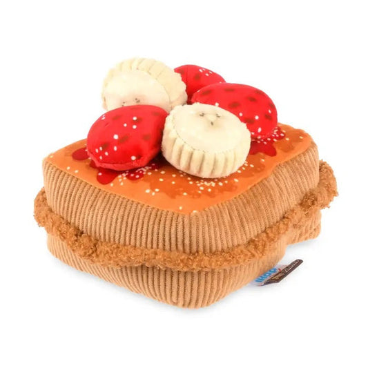 The THICK ‘N FLUFFY FRENCH TOAST DOG TOY by PLAY PET LIFESTYLES/BRANDS is a plush, squeaky dog toy designed to look like a delicious stack of French toast, topped with fabric strawberries, bananas, and syrup. Its soft texture and detailed brown edges resemble a real breakfast treat—perfect for pets who love an eco-friendly toy that looks good enough to eat.