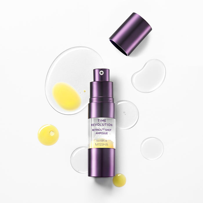 MISSHA Time Revolution Retinol 0.5 Shot Ampoule bottle with its cap off, surrounded by drops of yellow and clear serum, displayed on a clean white background to highlight its anti-aging formula and lightweight texture.