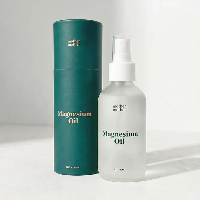 Green cylindrical container and white spray bottle labeled 'mother mother' on a light gray background