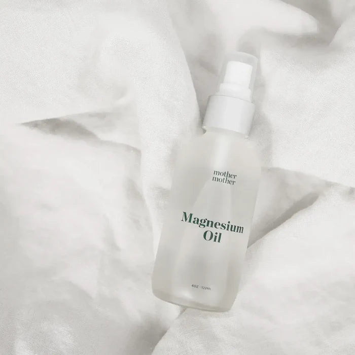 Bottle of magnesium oil with 'mother' branding on a white fabric background