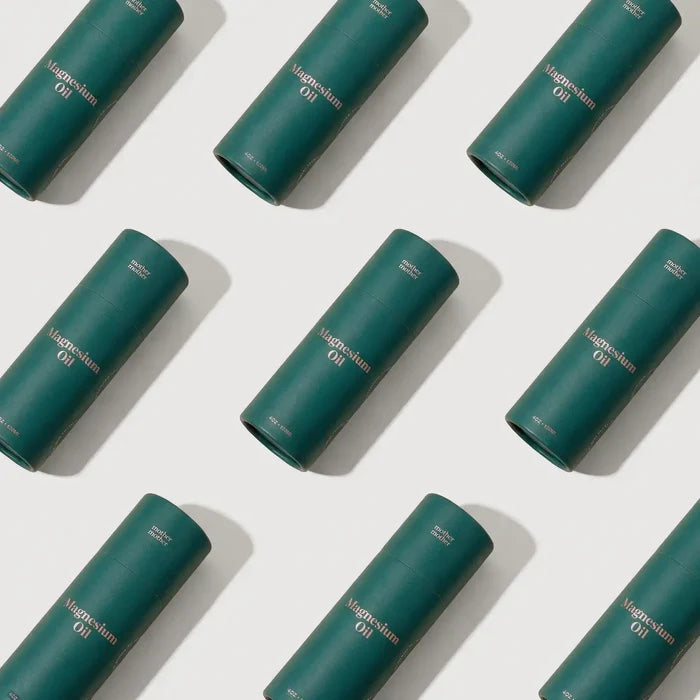Multiple green cylindrical containers labeled 'Magnesium Oil' arranged in a pattern on a white background.