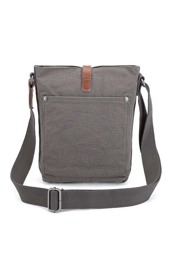 The TSD BRAND Forest Zip Crossbody Bag in Grey features a wide black strap, brown leather buckle accent, metal rivets, and a subtle side logo tag for a military-inspired look.