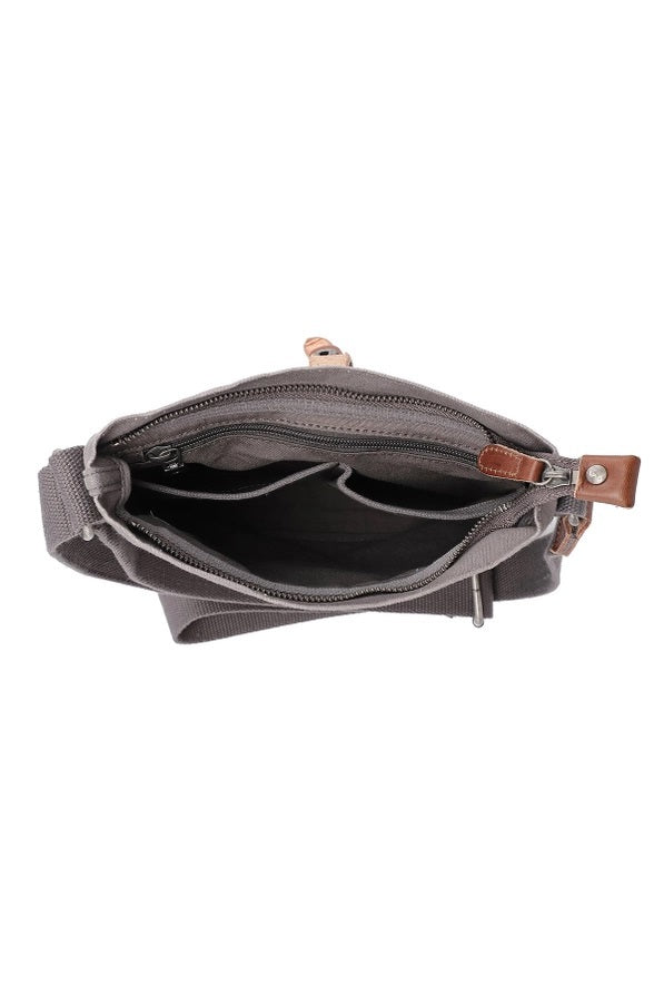 The TSD BRAND Forest Zip Crossbody Bag in Grey features a wide black strap, brown leather buckle accent, metal rivets, and a subtle side logo tag for a military-inspired look.