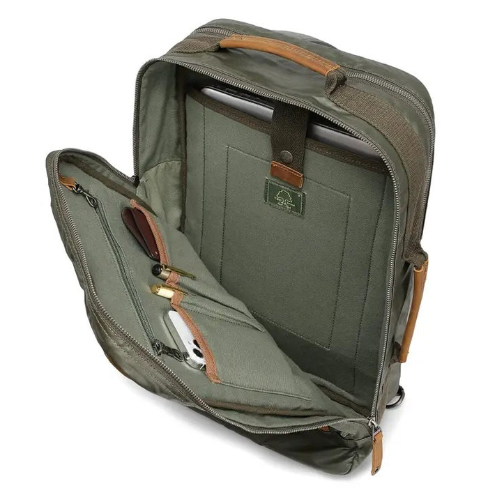 The TSD BRAND Madrone Coated Canvas Backpack in army green features brown leather accents, zippers, a top flap, side handles, metal rings, and a leather logo patch; shown lying flat to display these details.