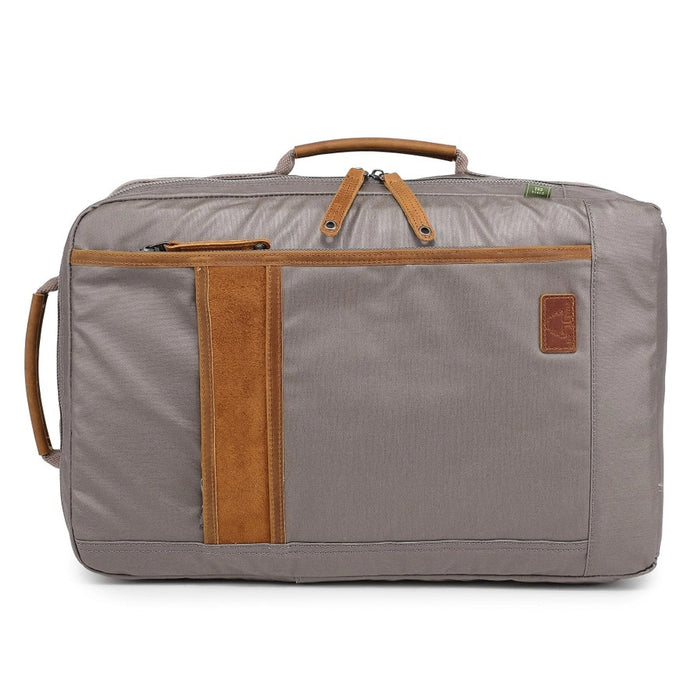 A close-up of the TSD BRAND - MADRONE Coated Canvas Backpack in Grey shows its brown leather accents and an unzipped front pocket with a black wallet partially visible inside.