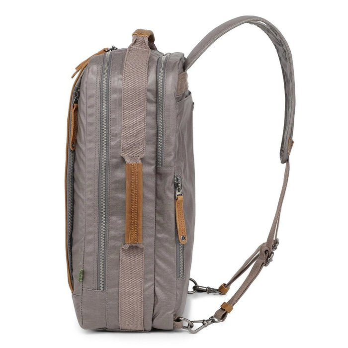 A close-up of the TSD BRAND - MADRONE Coated Canvas Backpack in Grey shows its brown leather accents and an unzipped front pocket with a black wallet partially visible inside.