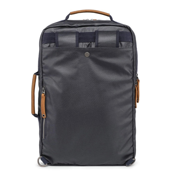 The TSD BRAND - MADRONE COATED CANVAS BACKPACK IN NAVY features brown leather accents, a spacious main compartment, a padded laptop sleeve with snap closure, and multiple zippered pockets on the inside flap.