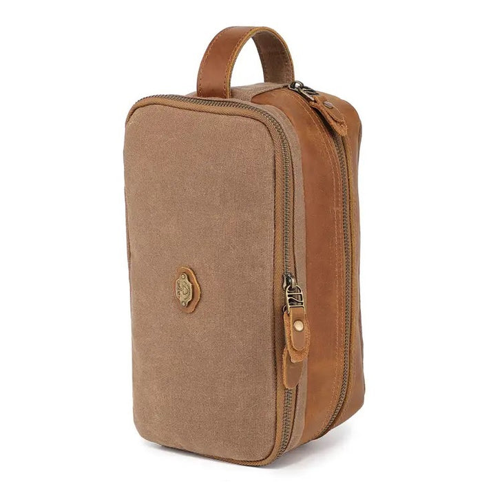 The TSD BRAND Turtle Ridge Toiletry Bag in khaki features leather accents, two zippered compartments, a side handle, and a small logo patch on the front pocket.