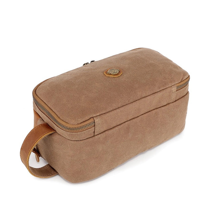 The TSD BRAND Turtle Ridge Toiletry Bag in khaki features leather accents, two zippered compartments, a side handle, and a small logo patch on the front pocket.