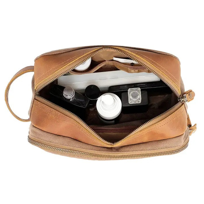 The TSD BRAND Turtle Ridge Toiletry Bag in khaki features leather accents, two zippered compartments, a side handle, and a small logo patch on the front pocket.