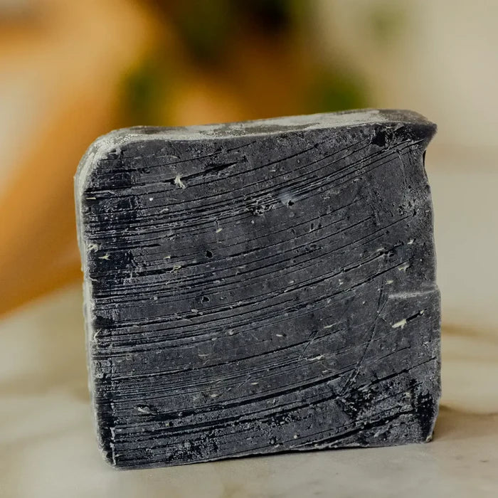 Bar of black soap on a neutral background