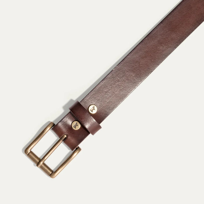 The WILL LEATHER GOODS - SADDLE BELT is a brown full-grain leather belt with a metal buckle and an embossed animal logo near the end, coiled on a plain white background—a timeless classic from WILL LEATHER GOODS for jeans.