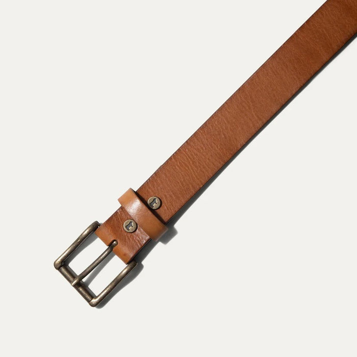 The WILL LEATHER GOODS - SADDLE BELT is a brown full-grain leather belt with a metal buckle and an embossed animal logo near the end, coiled on a plain white background—a timeless classic from WILL LEATHER GOODS for jeans.