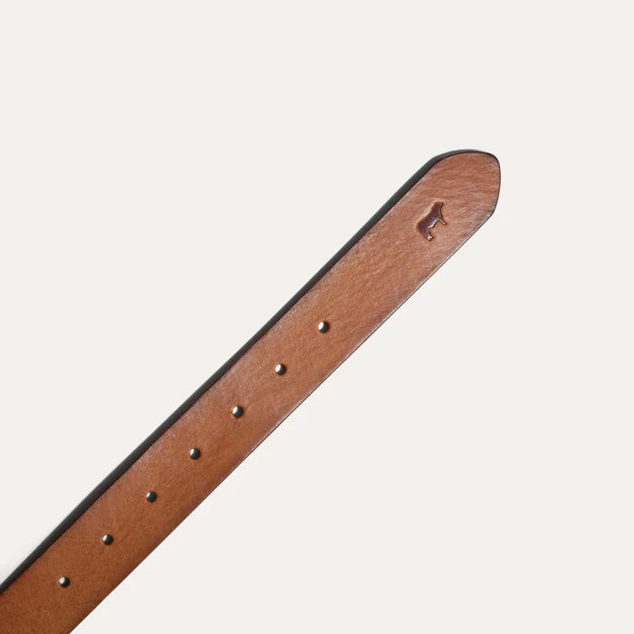 The WILL LEATHER GOODS - SADDLE BELT is a brown full-grain leather belt with a metal buckle and an embossed animal logo near the end, coiled on a plain white background—a timeless classic from WILL LEATHER GOODS for jeans.