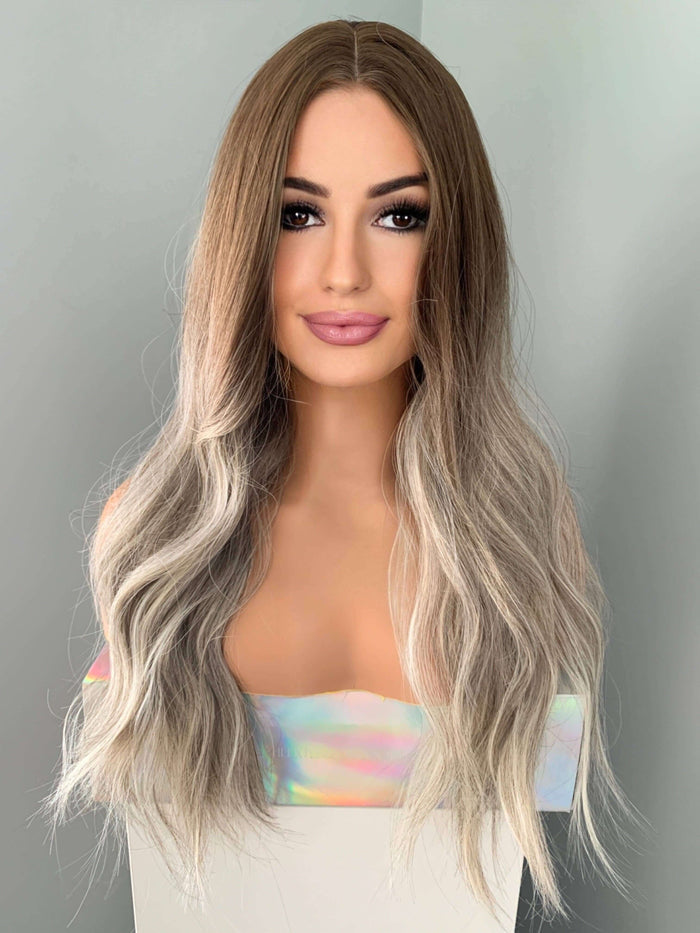 Long wavy grey silver wig featuring natural beachy waves and blended ash brown and blonde highlights.